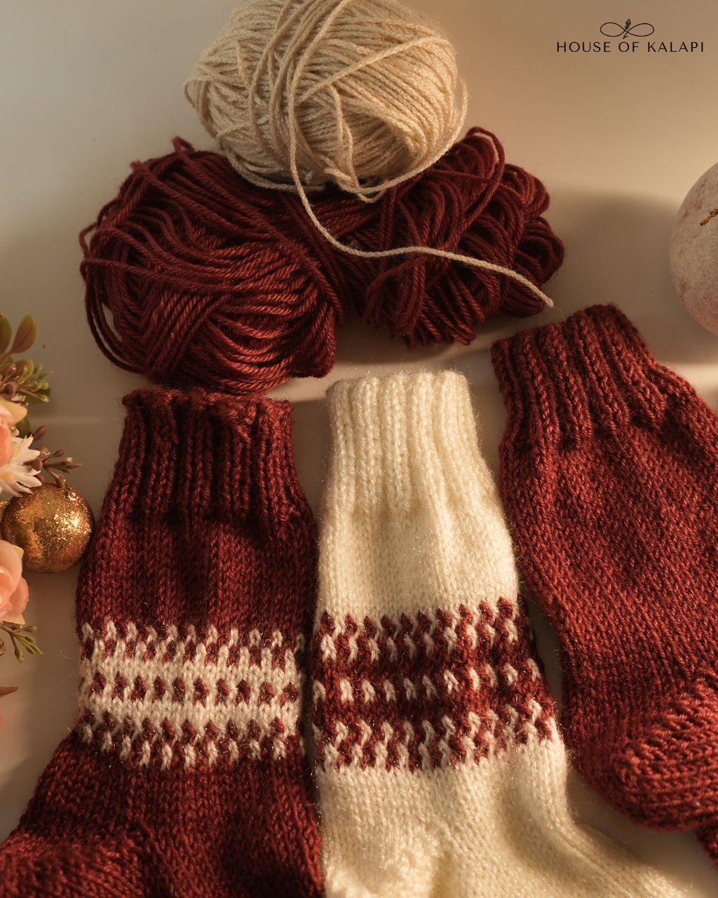 Close-up of cream and maroon hand-knit wool socks arranged with yarn: House of Kalapi Pack of 3.